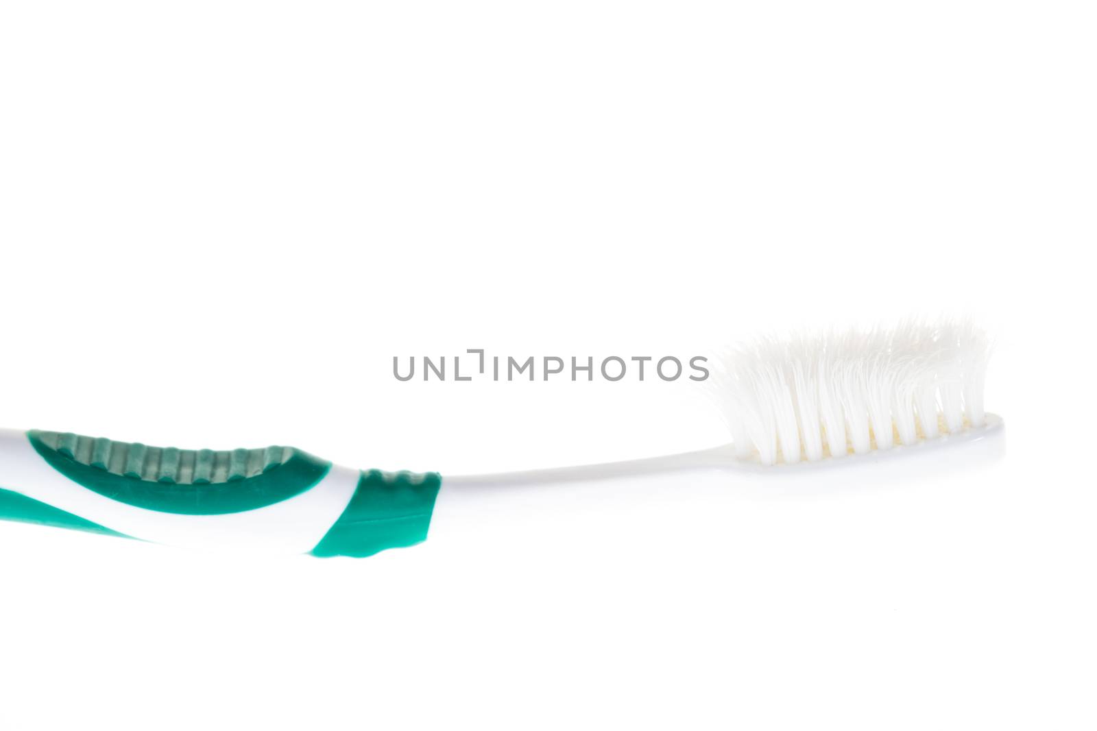 Green worn toothbrush on white background