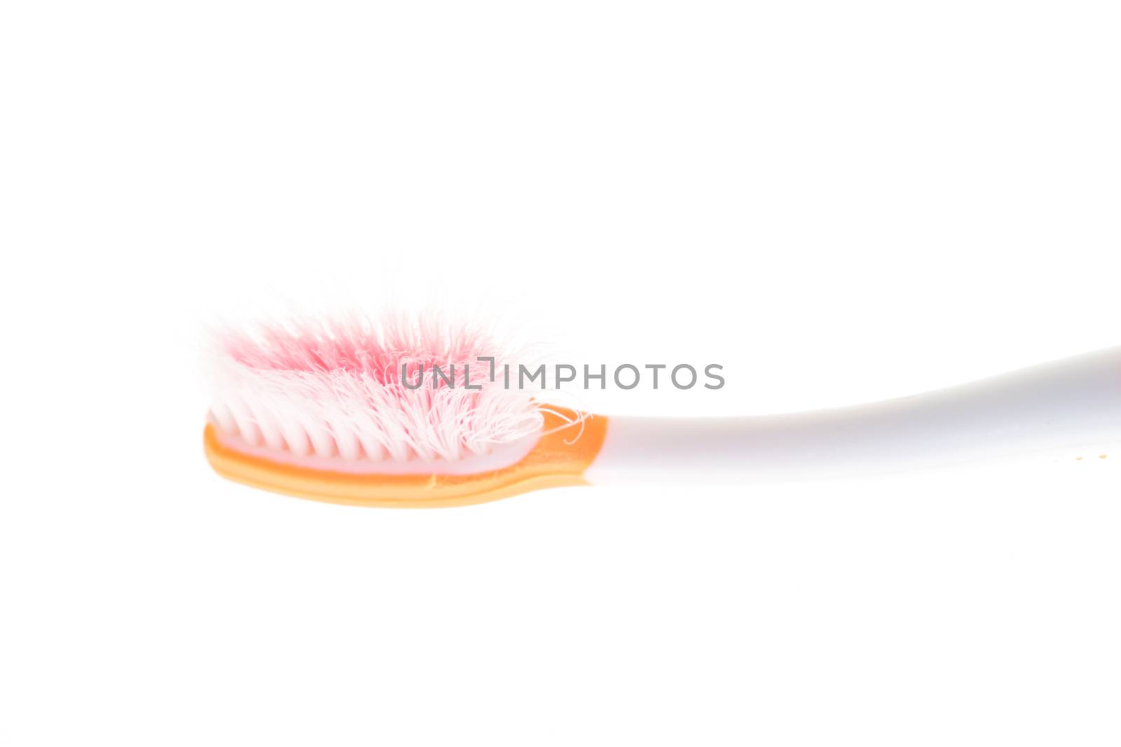 Orange worn toothbrush on isolated white background by iamway
