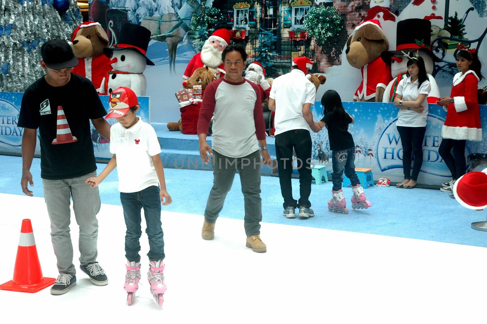 bandung, indonesia-december 17, 2011: girl and boy learning inline skate at bandung supermall venue.