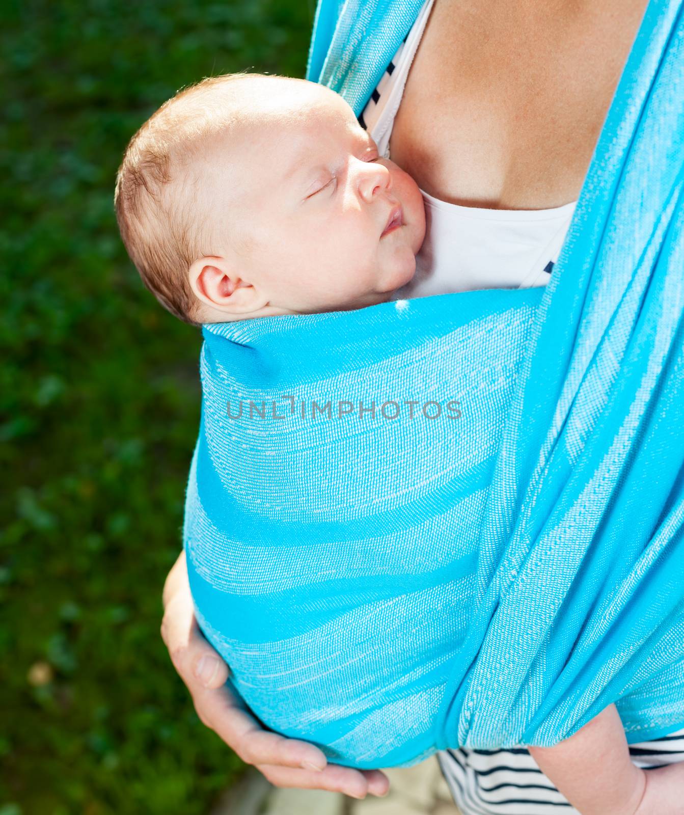 Woman with newborn baby in sling by naumoid