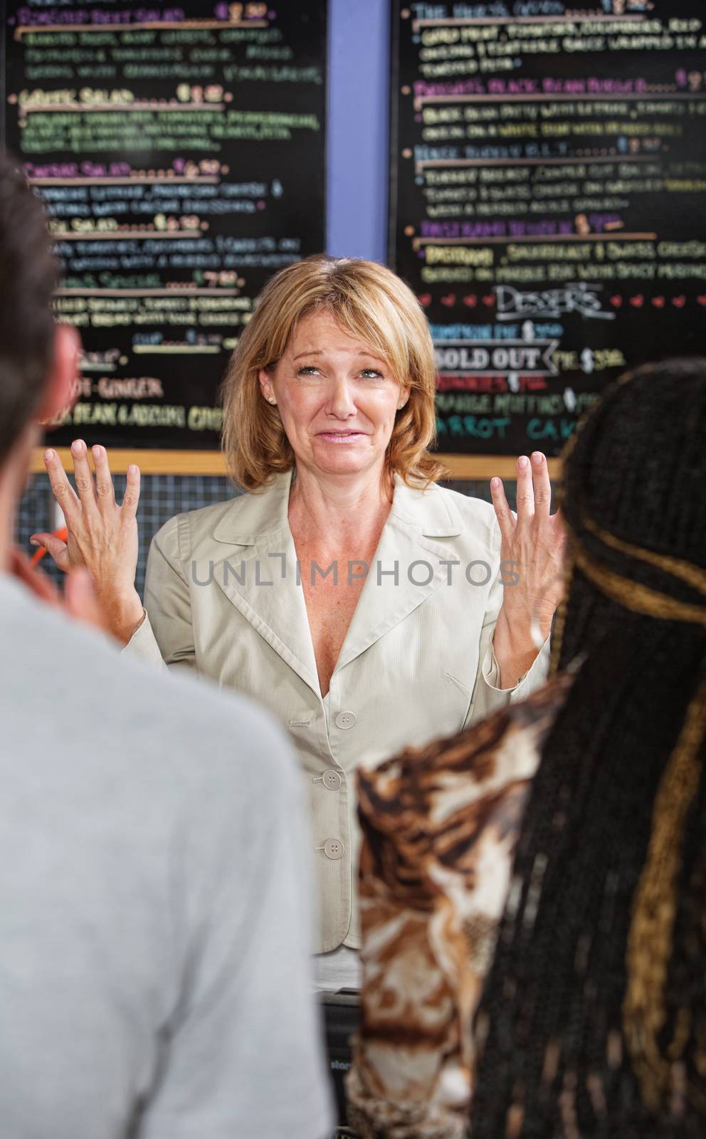 Panicked coffee house owner taking orders from customers