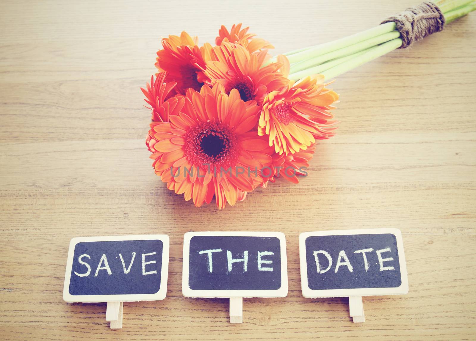 Save the date written on blackboard with flower, retro filter effect