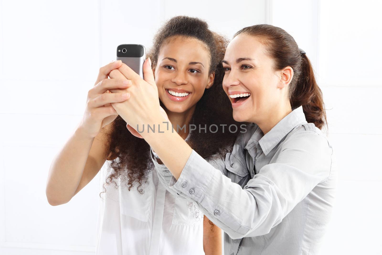 Two women take pictures with your phone by robert_przybysz