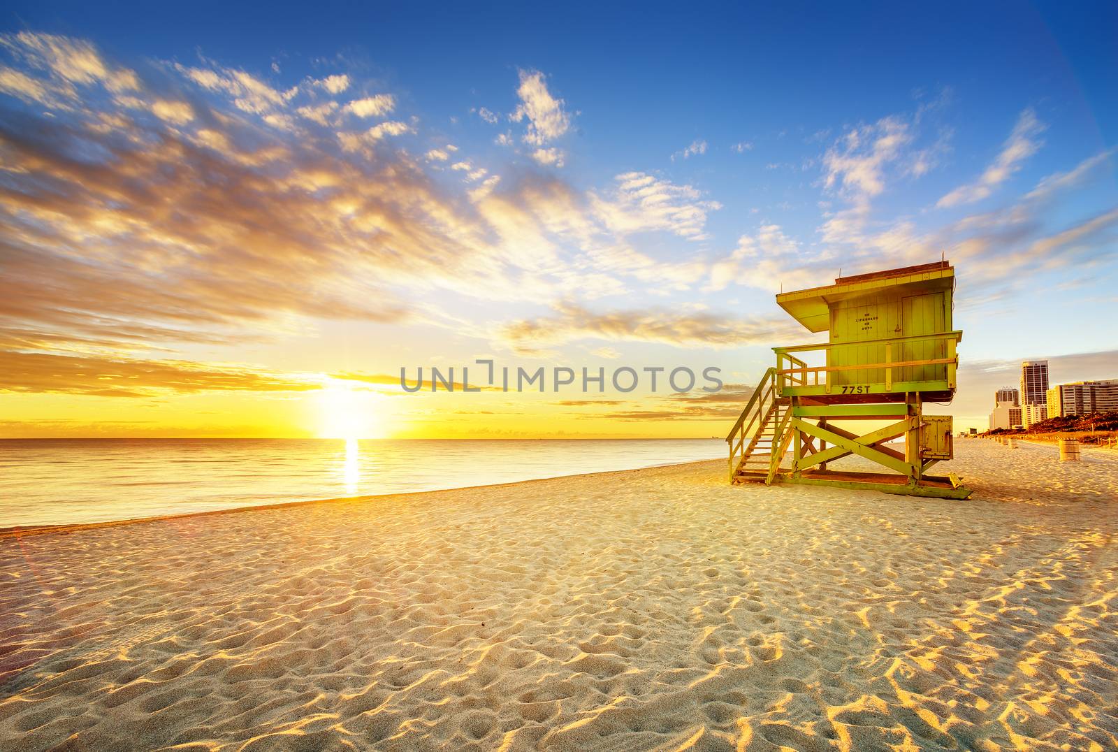 Miami South Beach sunrise with lifeguard tower and coastline with colorful cloud and blue sky. 