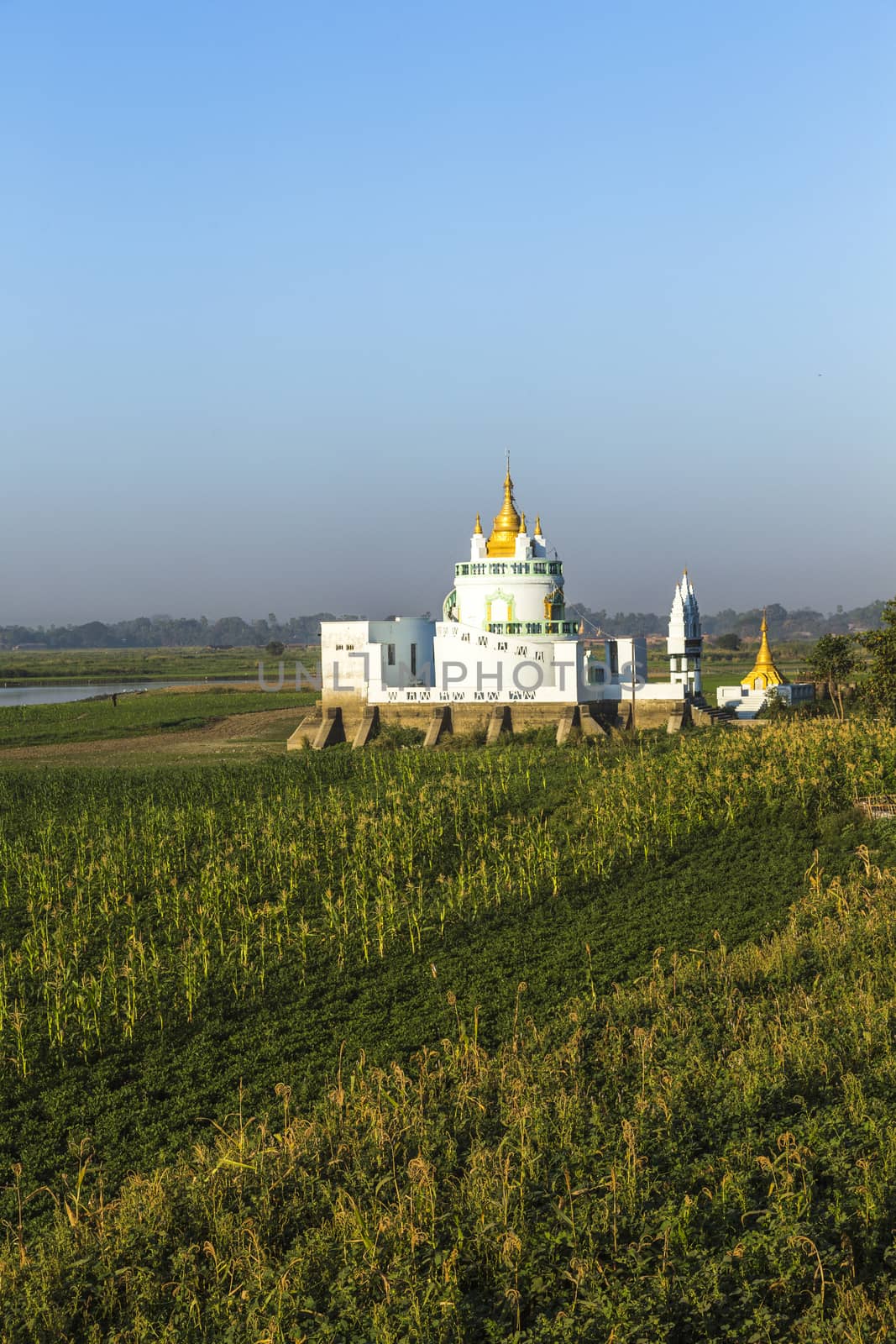 White pagoda at Ubein bridge. World longest wooden bridge. Mandalay. Myanmar