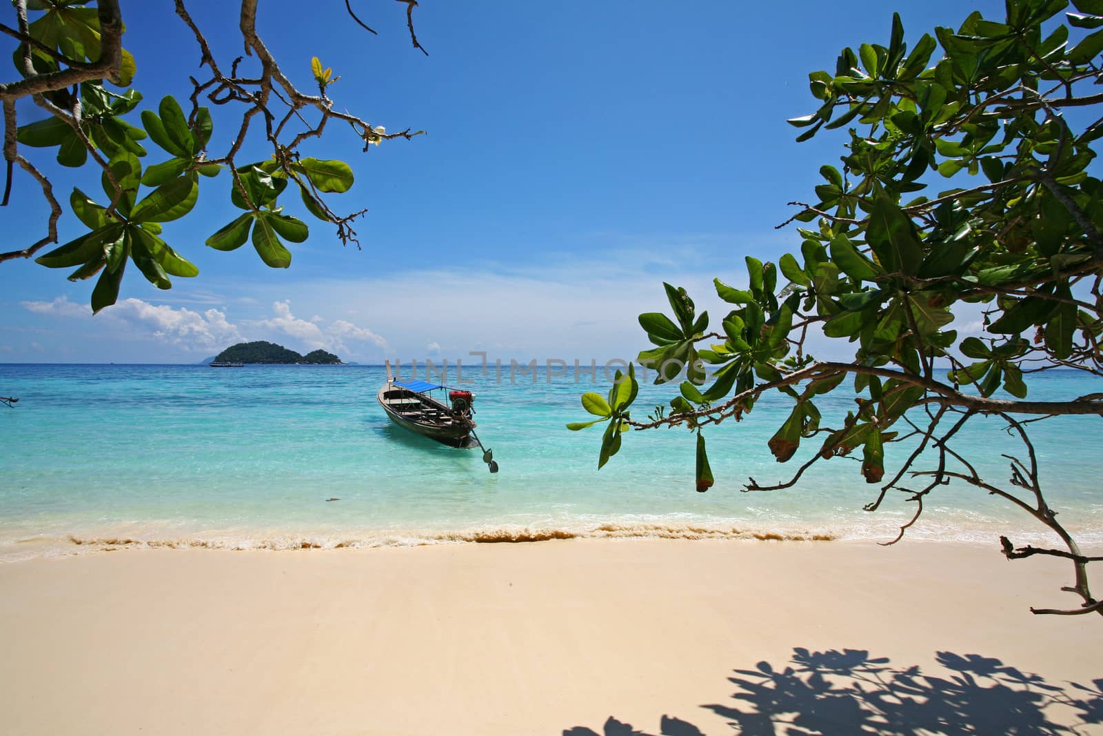 Andaman Seascape with boat, mountain, white sand and blue sky, mu ko surin, thailand