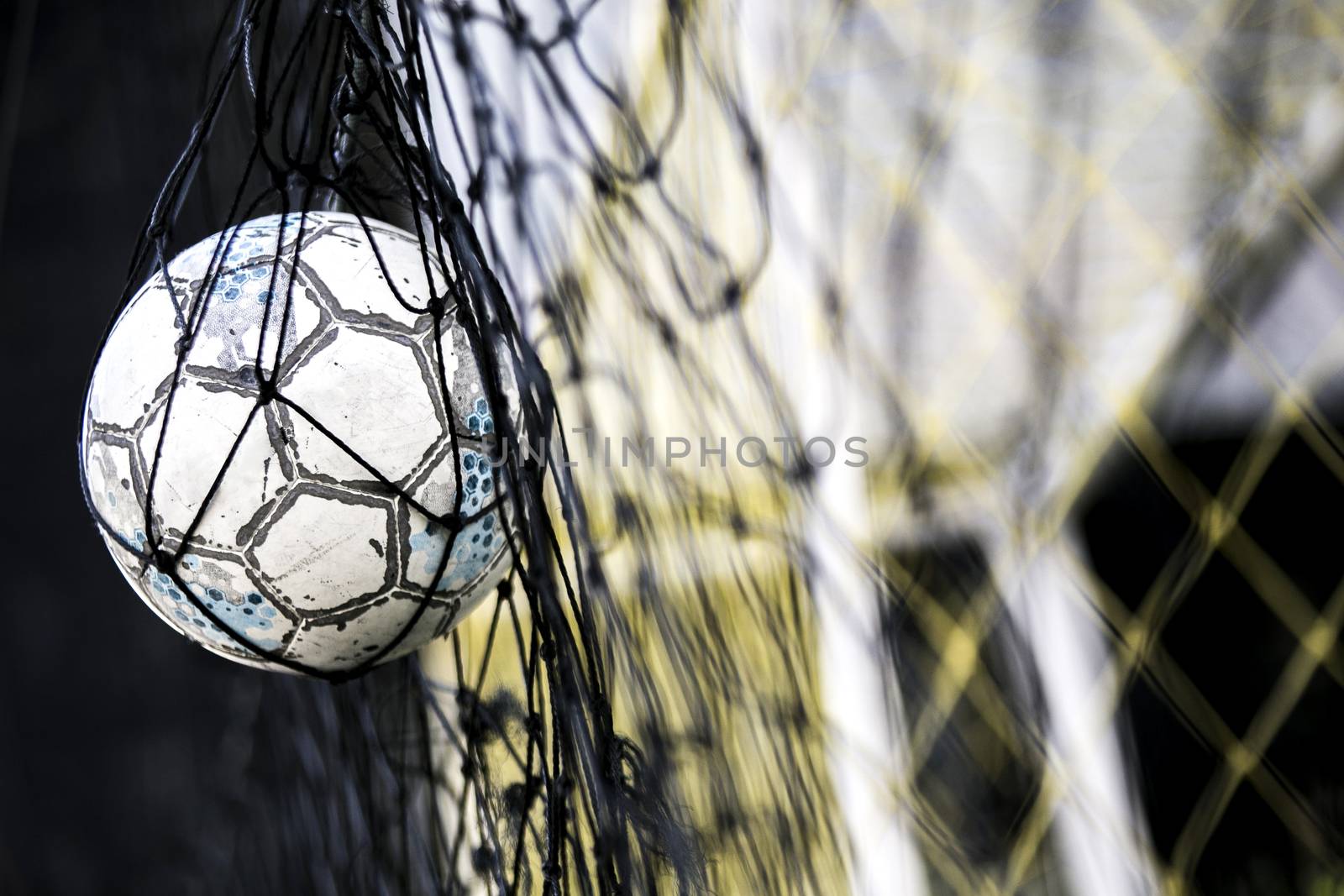 A soccer ball stuck on the net behind goal  by 2nix