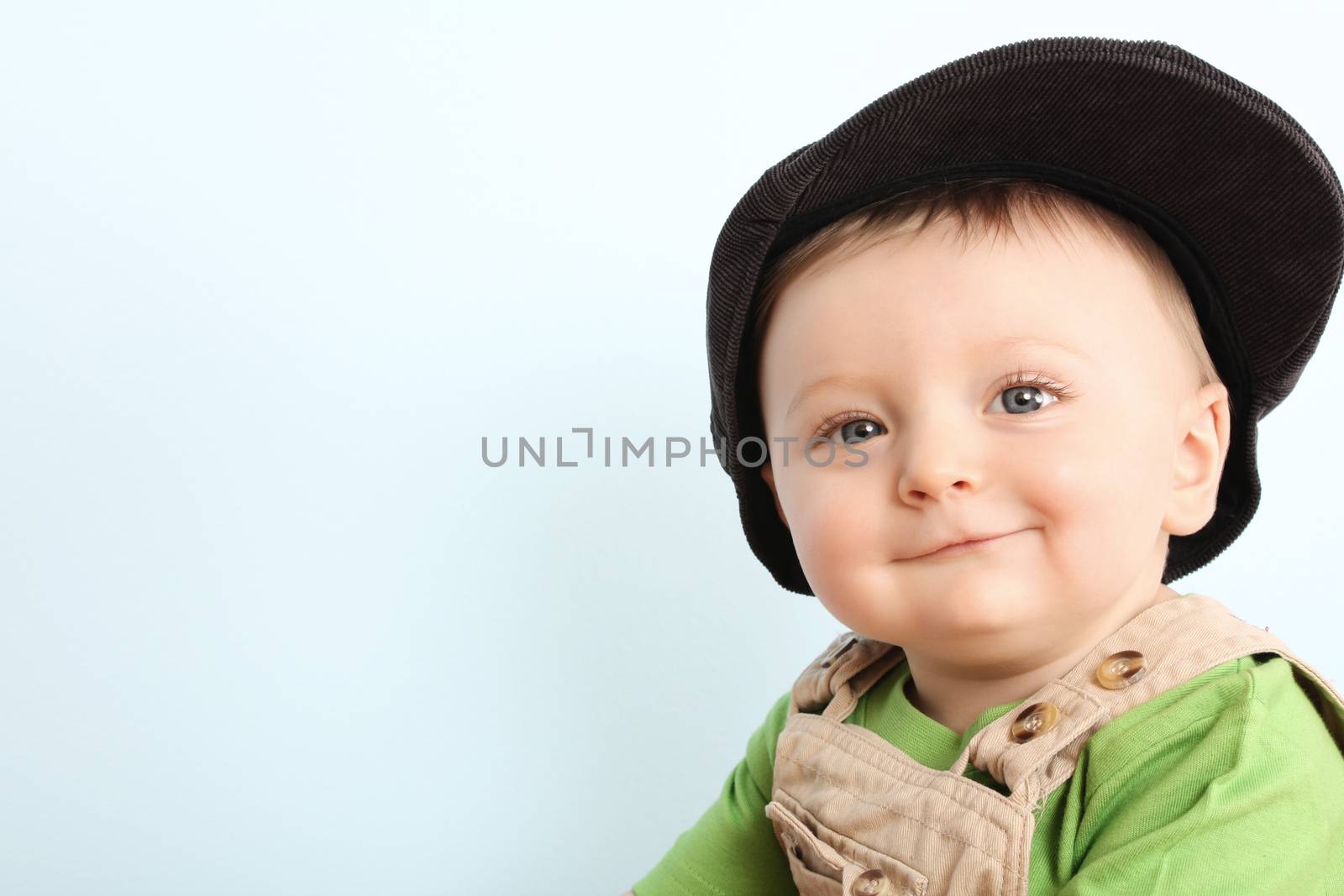 Little boy wearing a hat against blue background