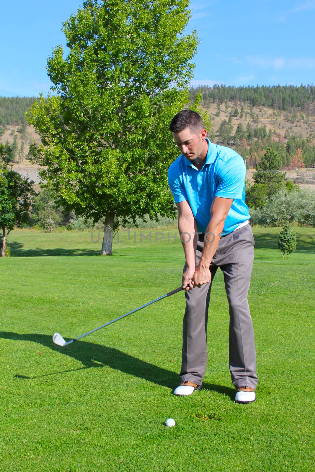 Young golfer hitting a shot with an iron 