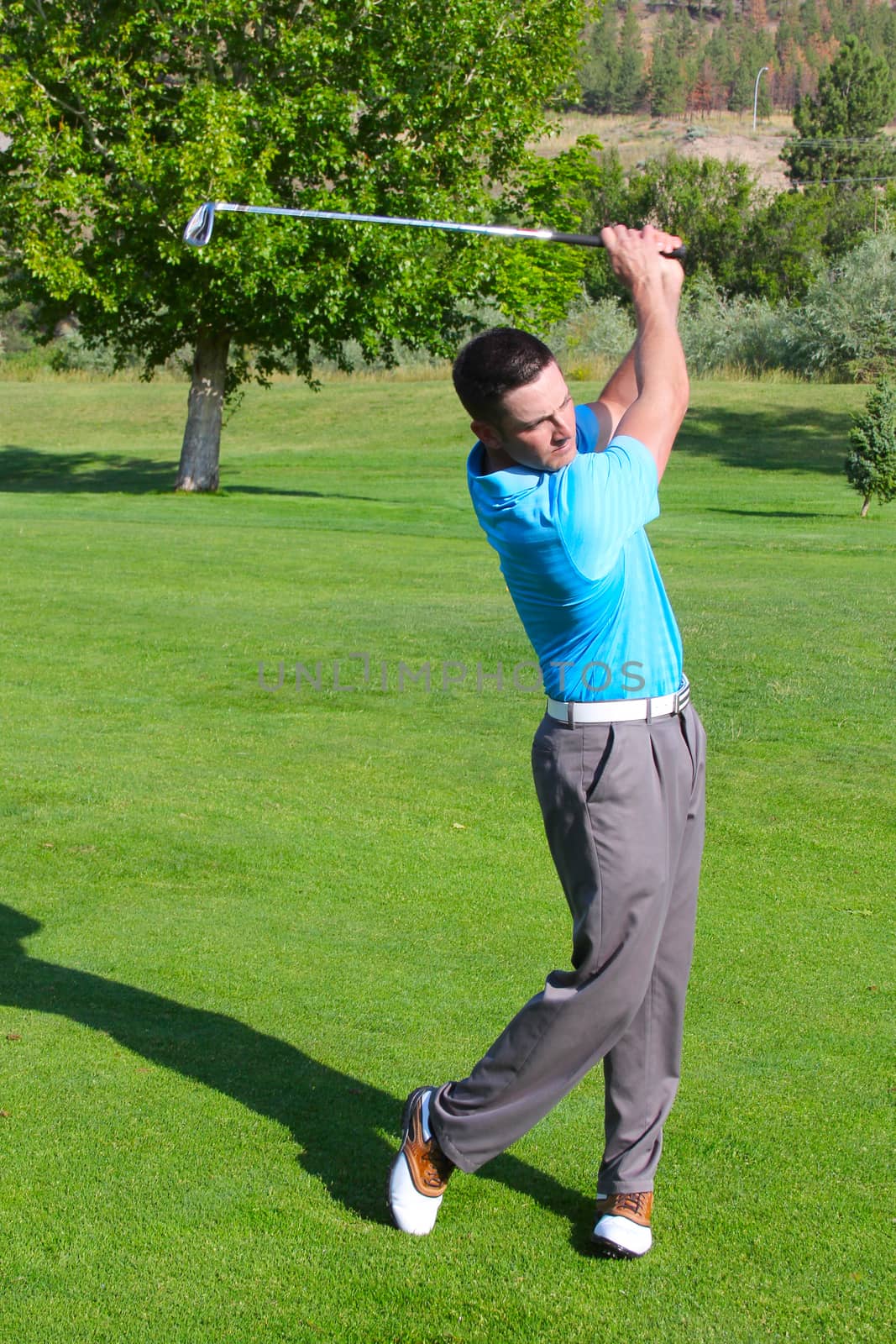 Young golfer hitting a shot with an iron 