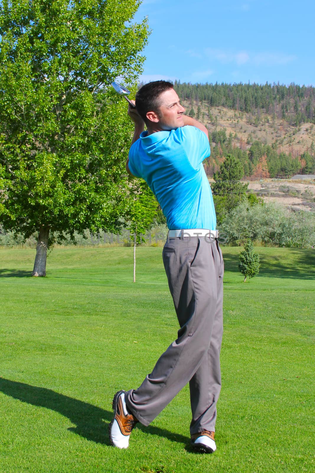 Young golfer hitting a shot with an iron 