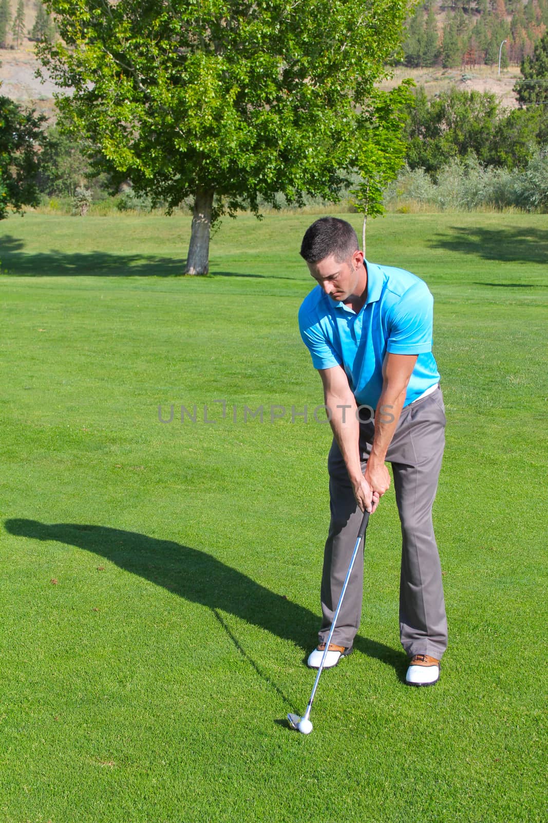 Young golfer hitting a shot with an iron 