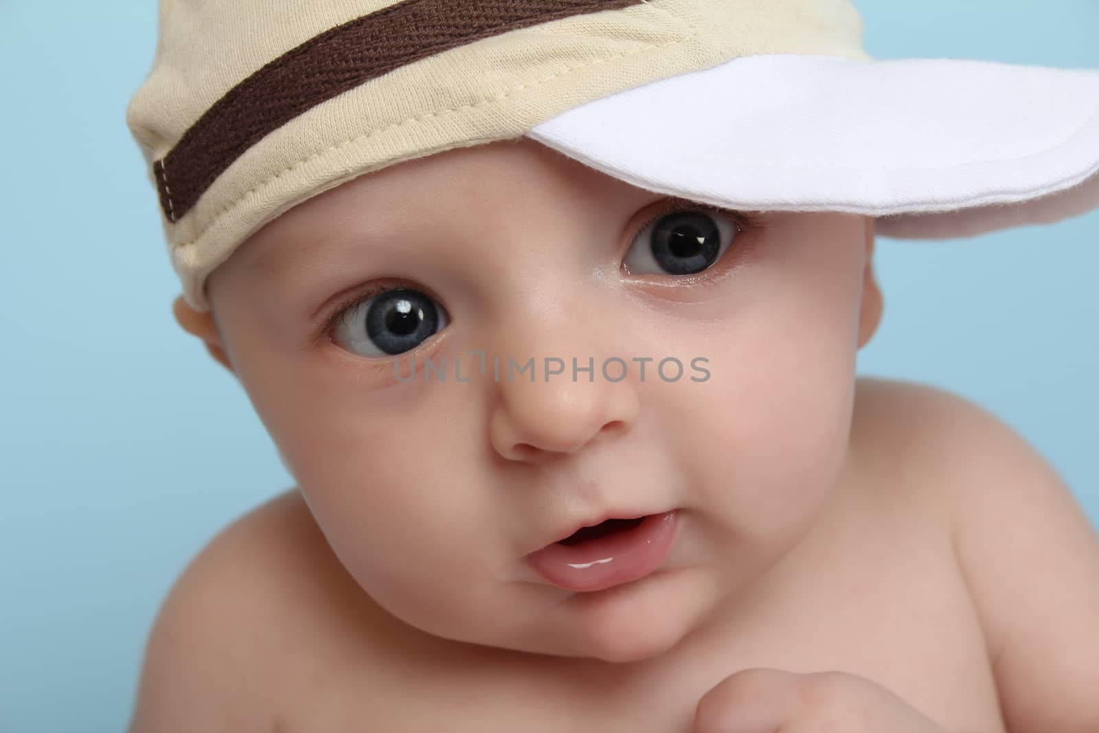 Baby boy wearing a hat against blue background