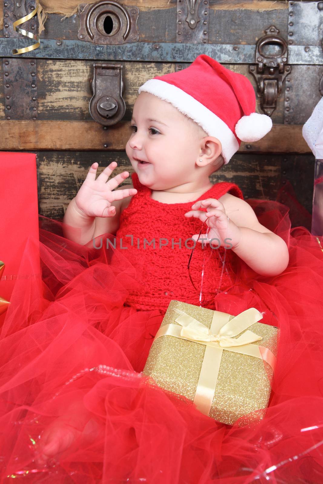 Brunette christmas baby girl wearing a long red tulle dress