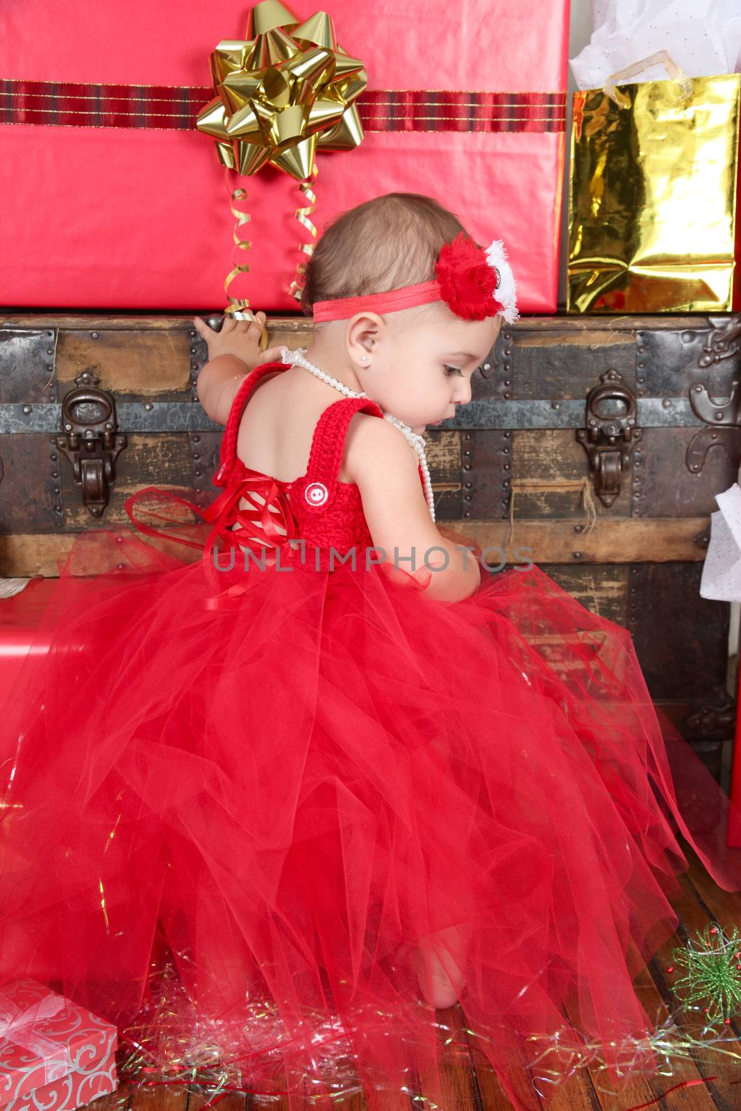 Brunette christmas baby girl wearing a long red tulle dress