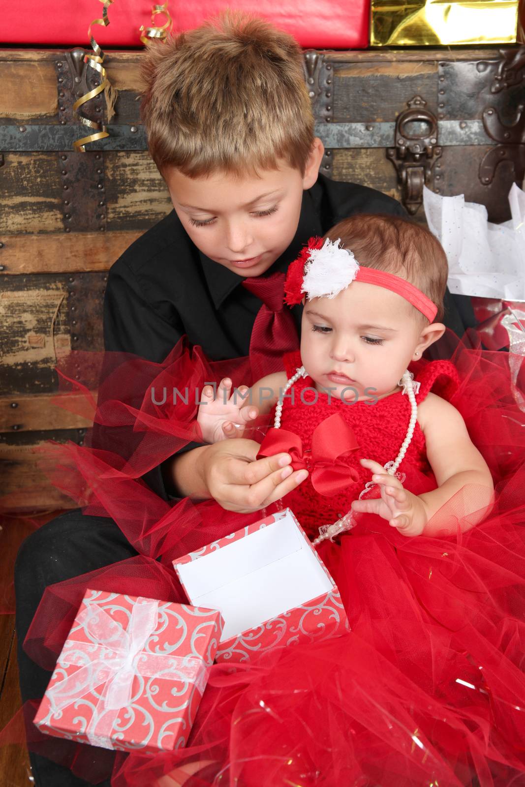 Young boy with his baby sister opening a gift box