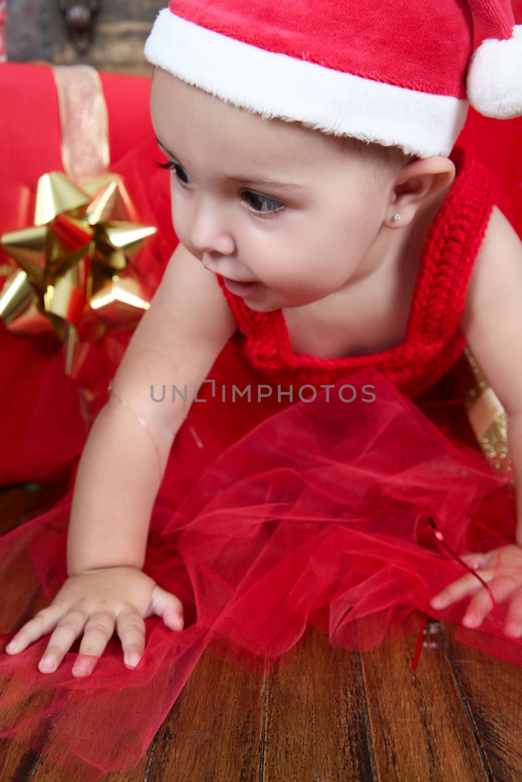 Brunette christmas baby girl wearing a long red tulle dress