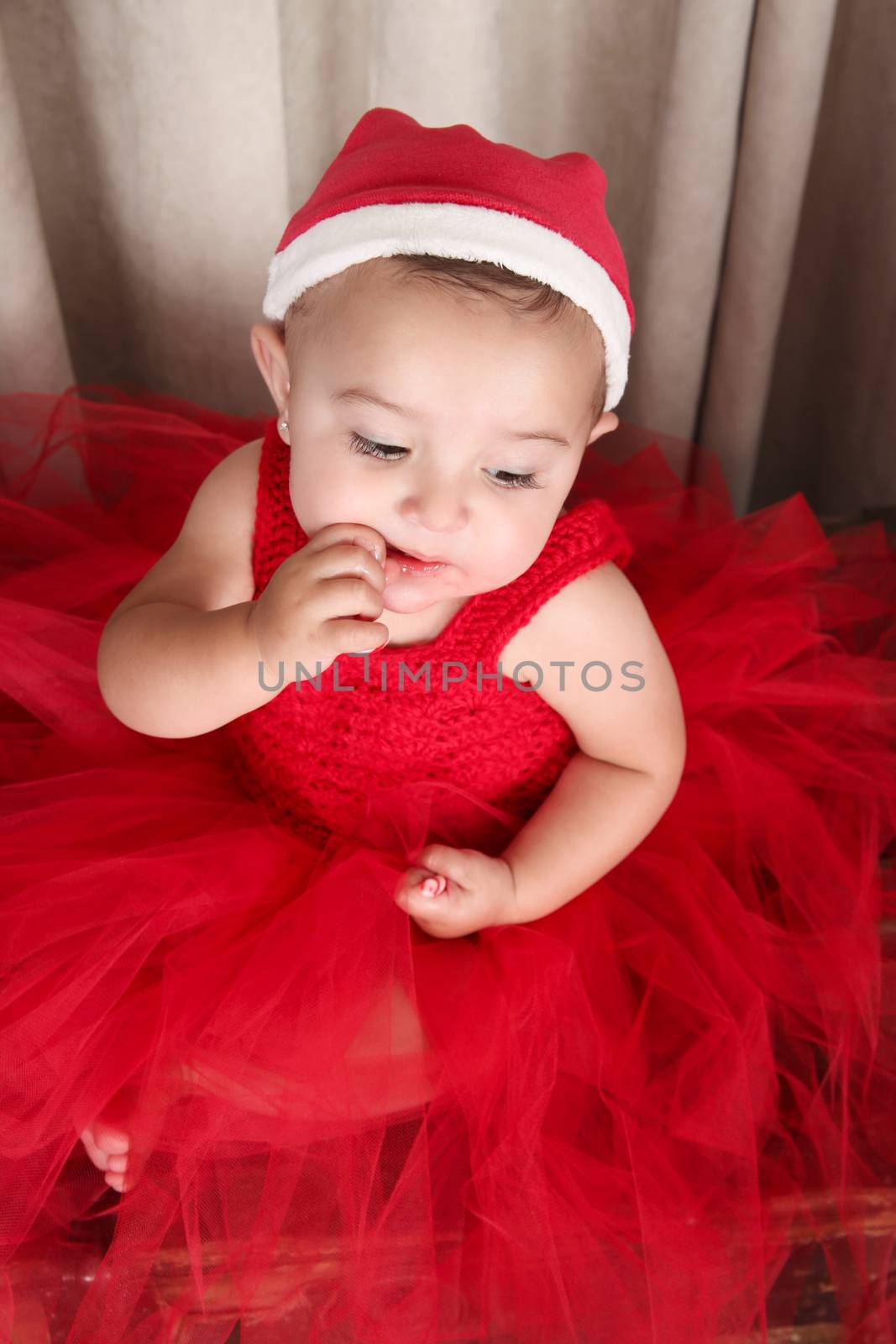 Brunette christmas baby girl wearing a long red tulle dress