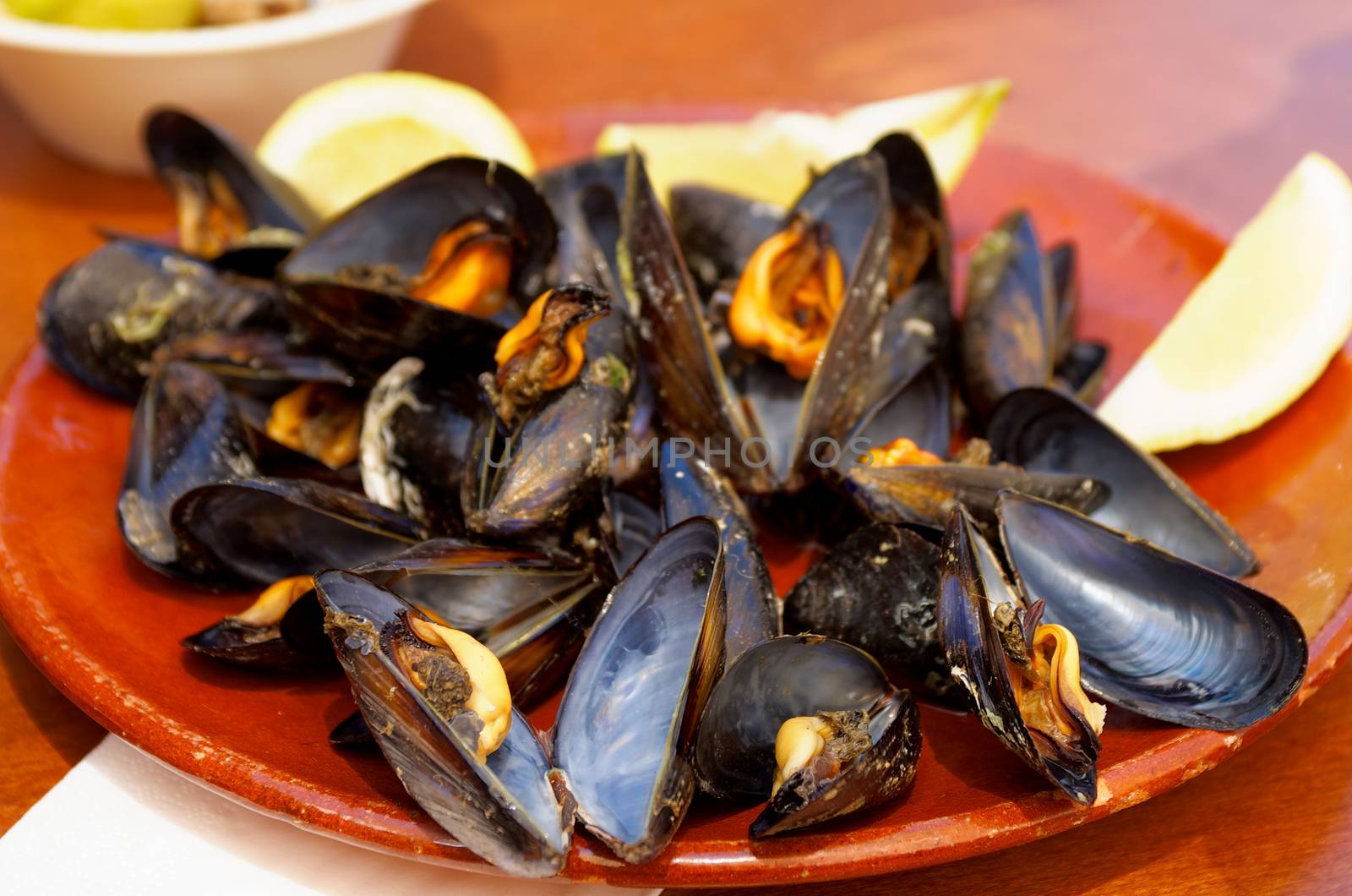 Fresh Cooked Boiled Mussels in Shells on Old Plate Served with Lemon on Wooden background