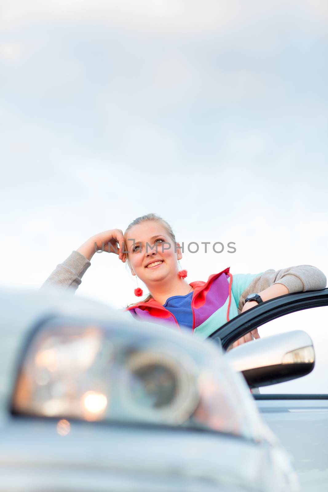 Portrait of a cheerful female teen driver, by her new car by viktor_cap
