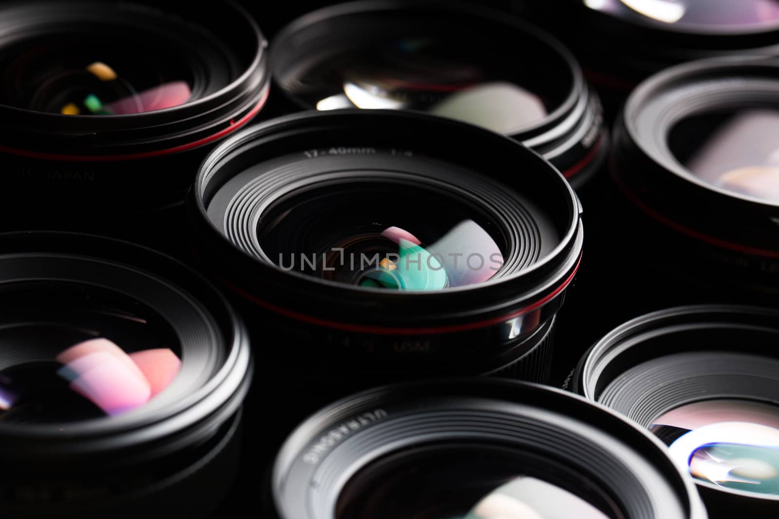 Modern camera lenses with reflections, low key image by viktor_cap