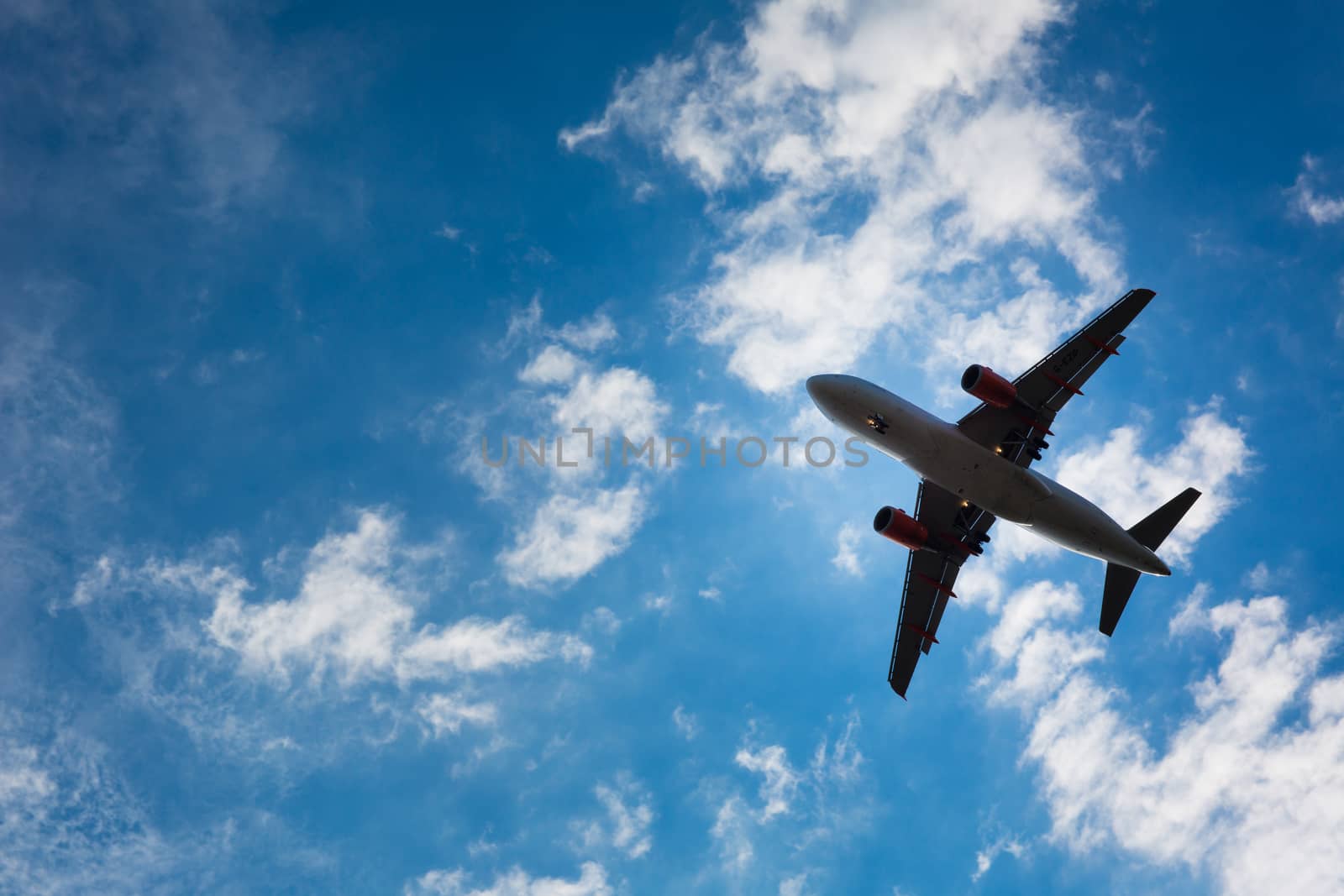 Dark silhouette of an airplane flying over the blue skies by viktor_cap