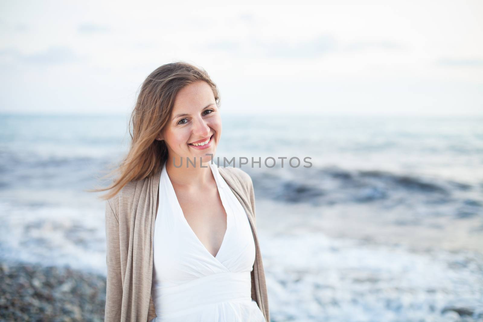 Young woman on the beach enjoying a warm summer evening on the seacoast