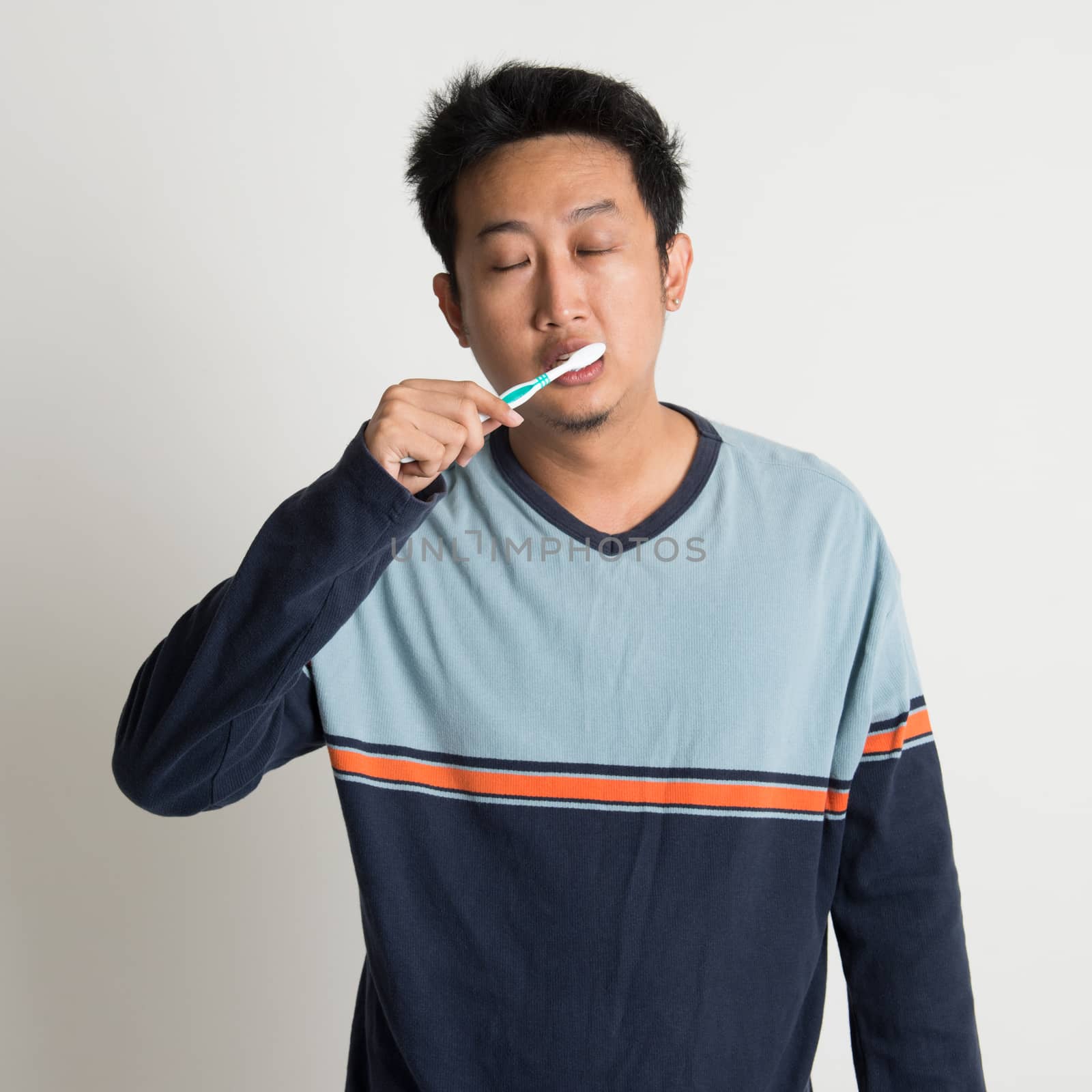 Asian male brushing teeth  by szefei