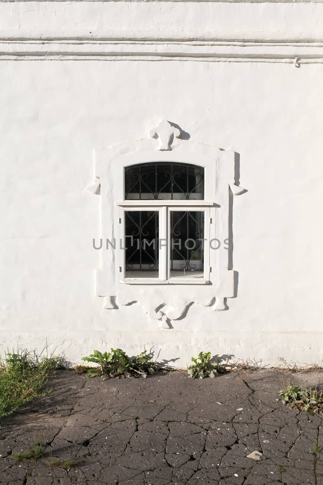 monastic cell window on old white wall of the monastery
