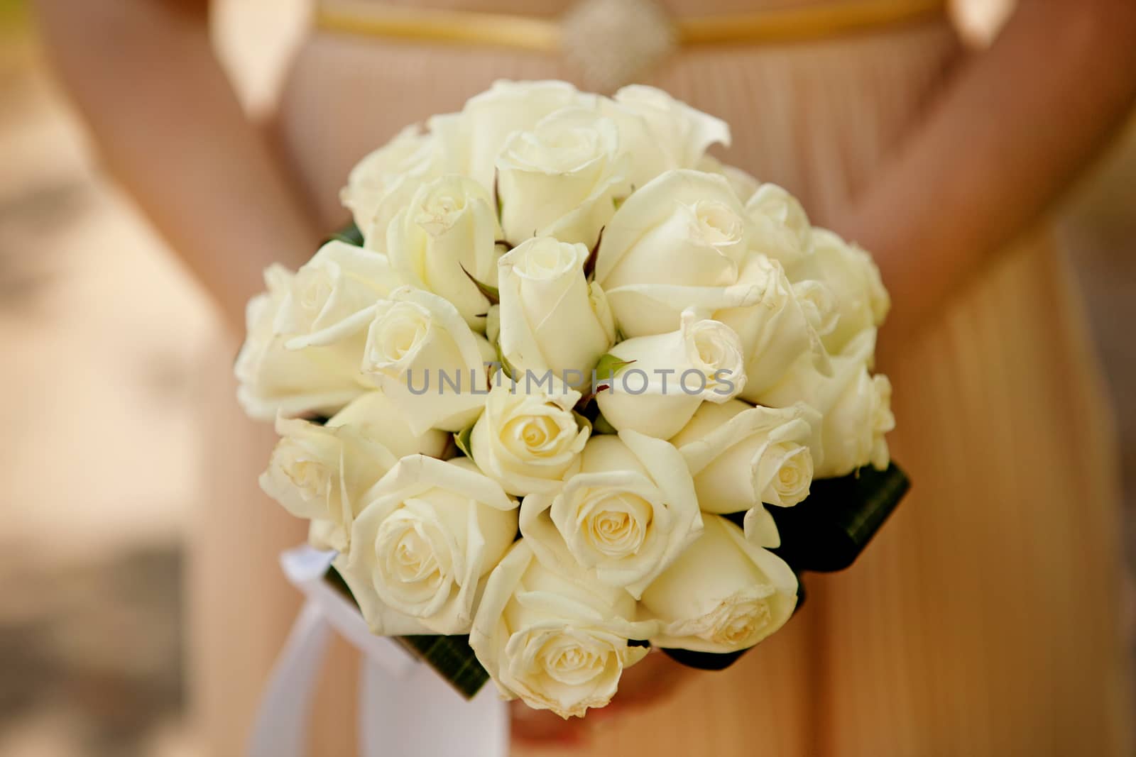 Bride holding wedding flower bouquet of yellow roses