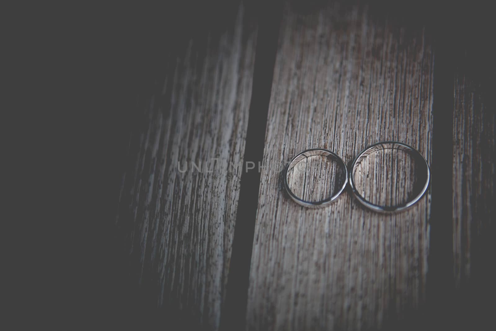 two wedding golden rings on wooden surface