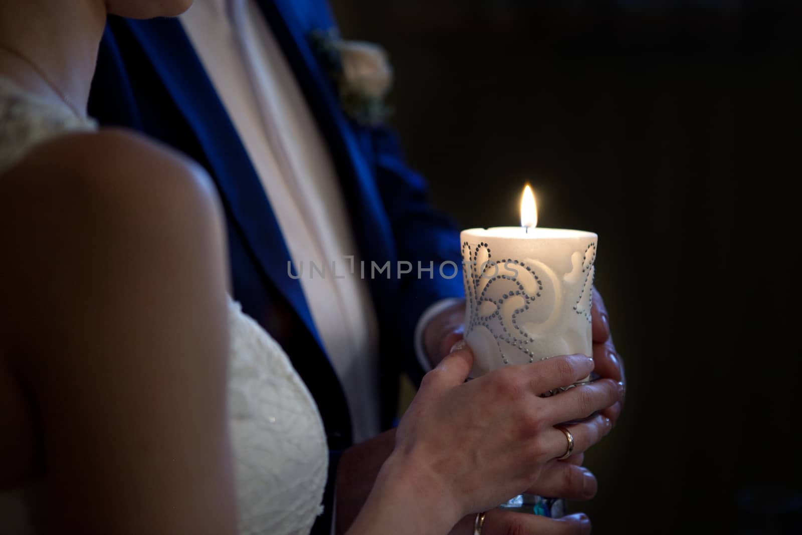 bride and groom holding a candle in church