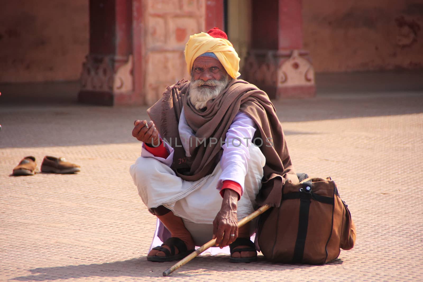 Indian man sitting at train station, Sawai Madhopur, Rajasthan, India