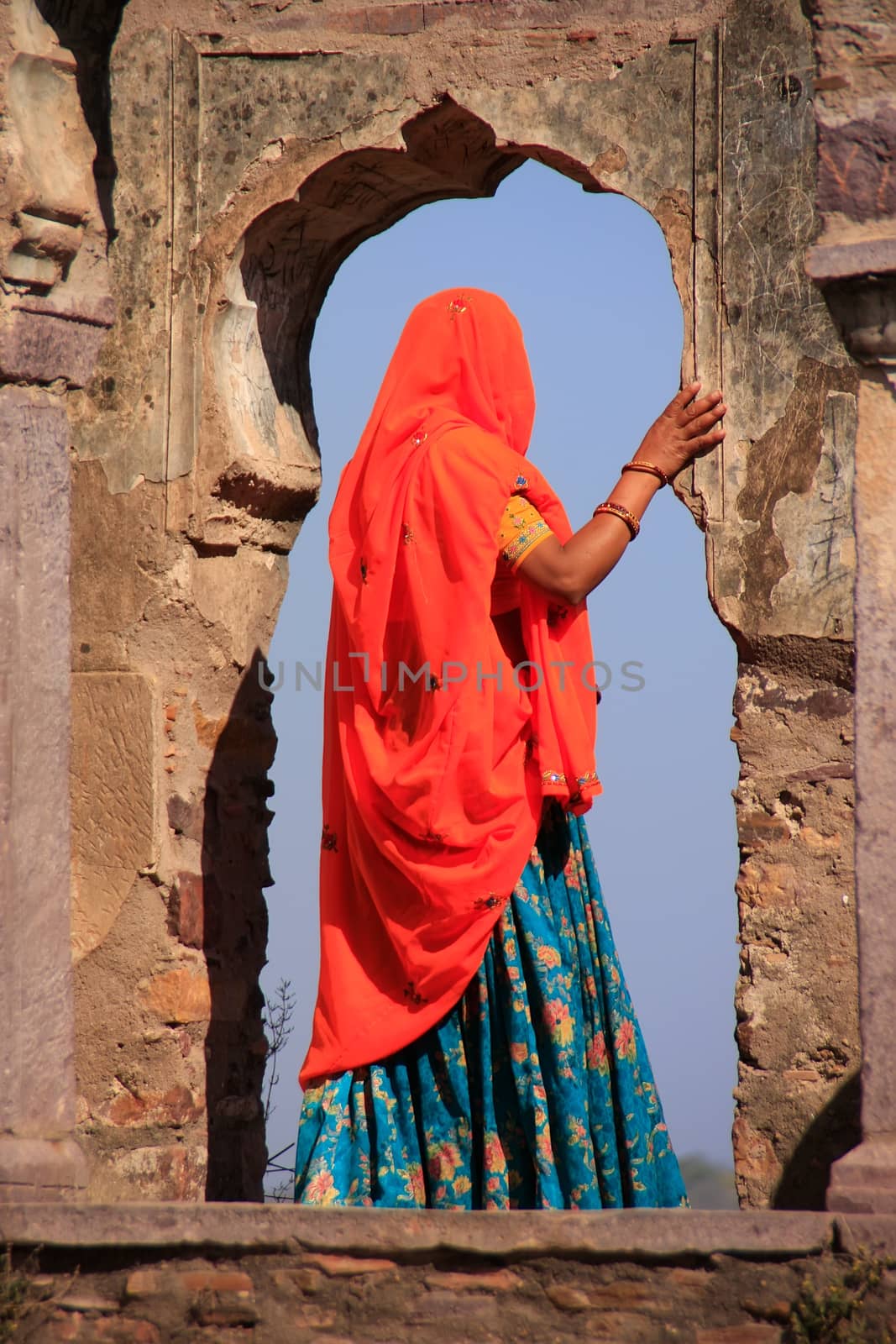 Indian woman in colorful sari standing in the arch, Ranthambore Fort, Rajasthan, India