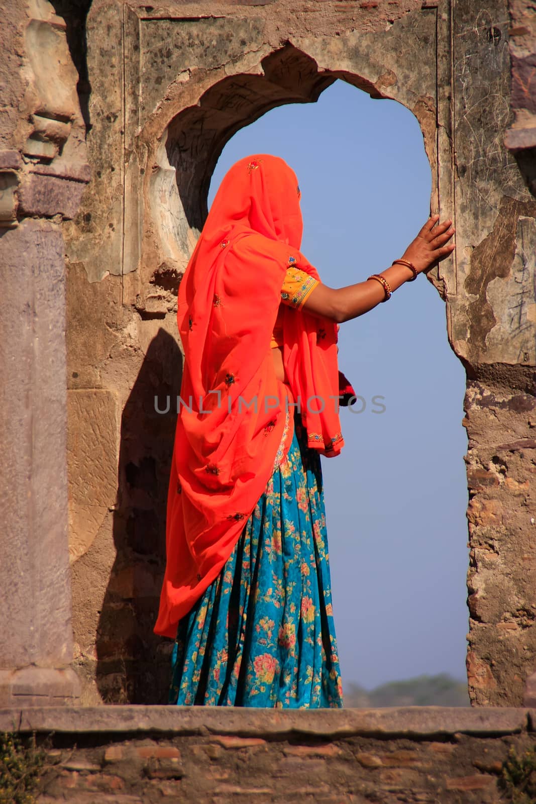 Indian woman in colorful sari standing in the arch, Ranthambore Fort, Rajasthan, India