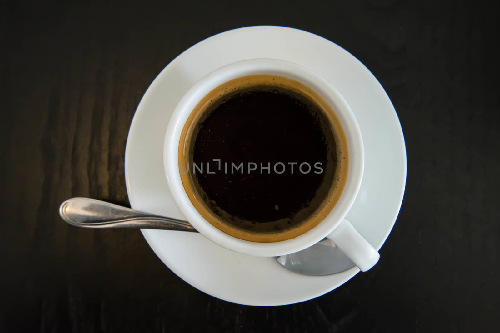 Black coffee in white cup on the wooden table.