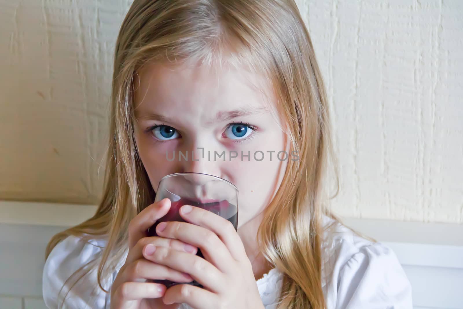 Cute girl with blond long hair drinking beverage