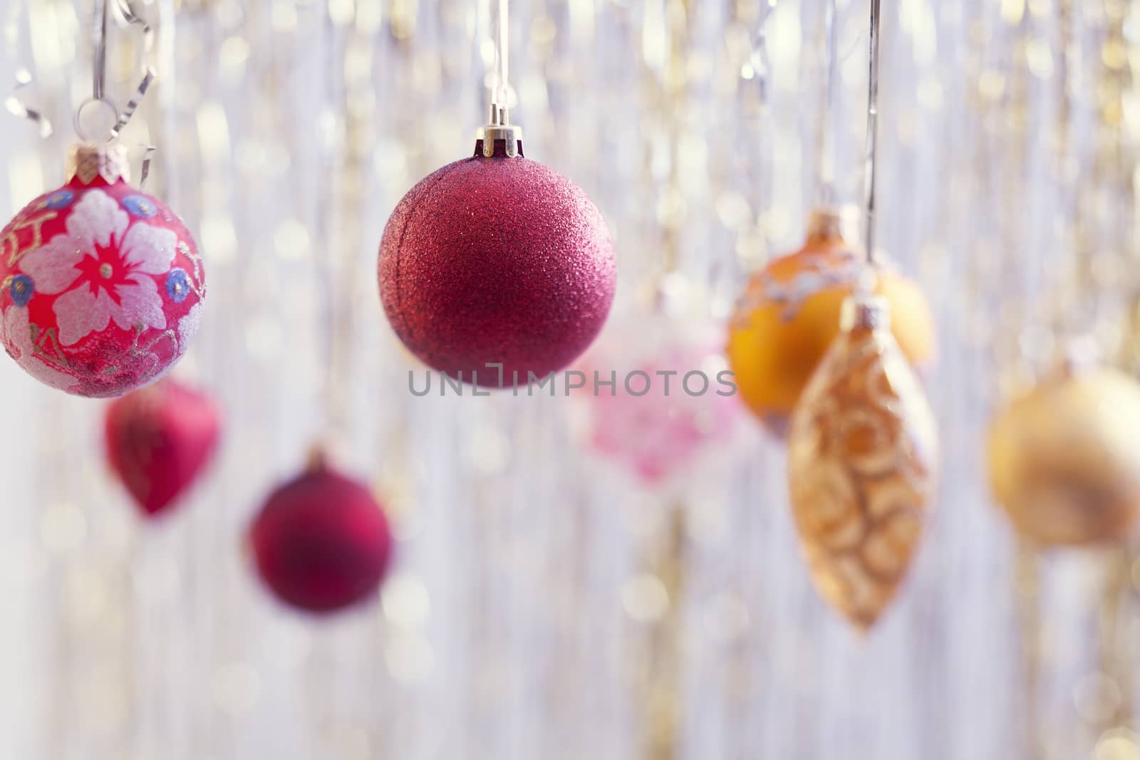 Red christmas balls hanging over silver background