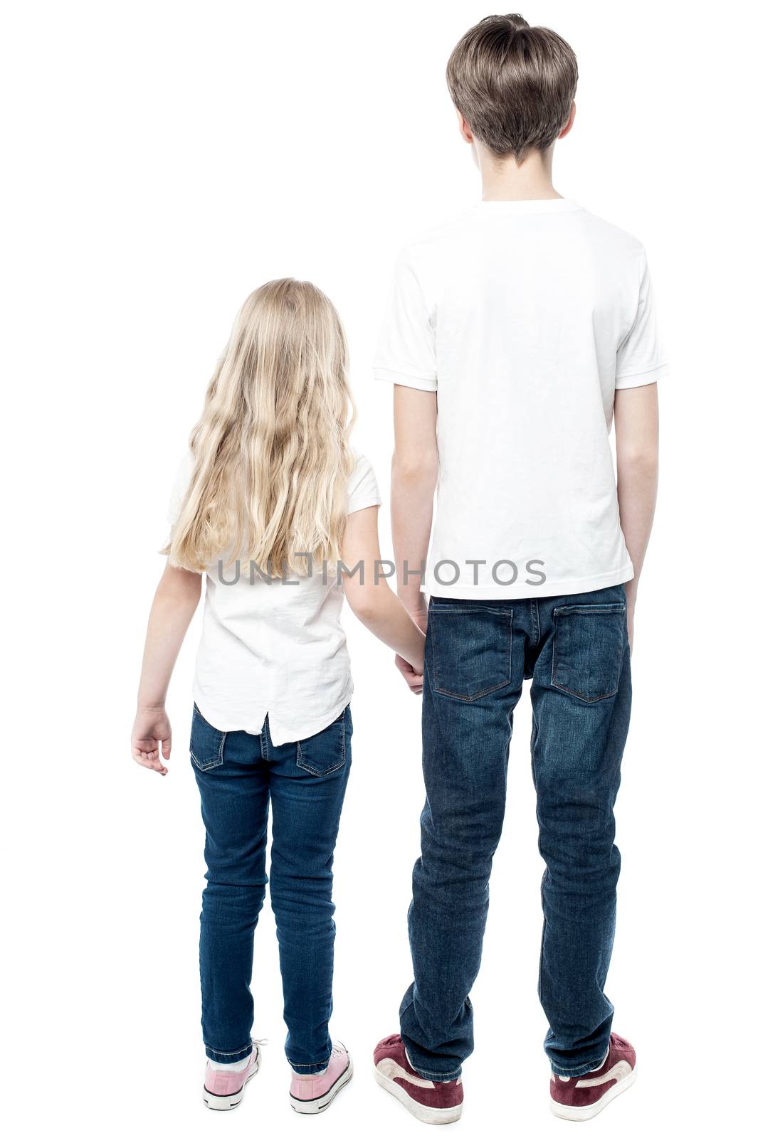 Rear view of young brother and sister with holding hands