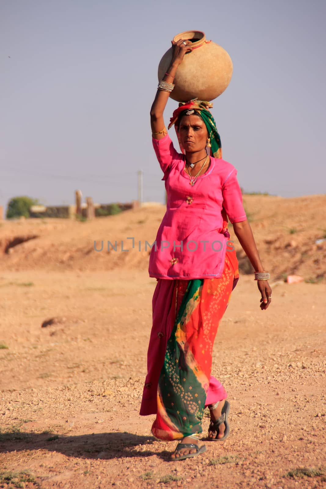 Local woman carrying jar with water on her head, Khichan village, Rajasthan, India