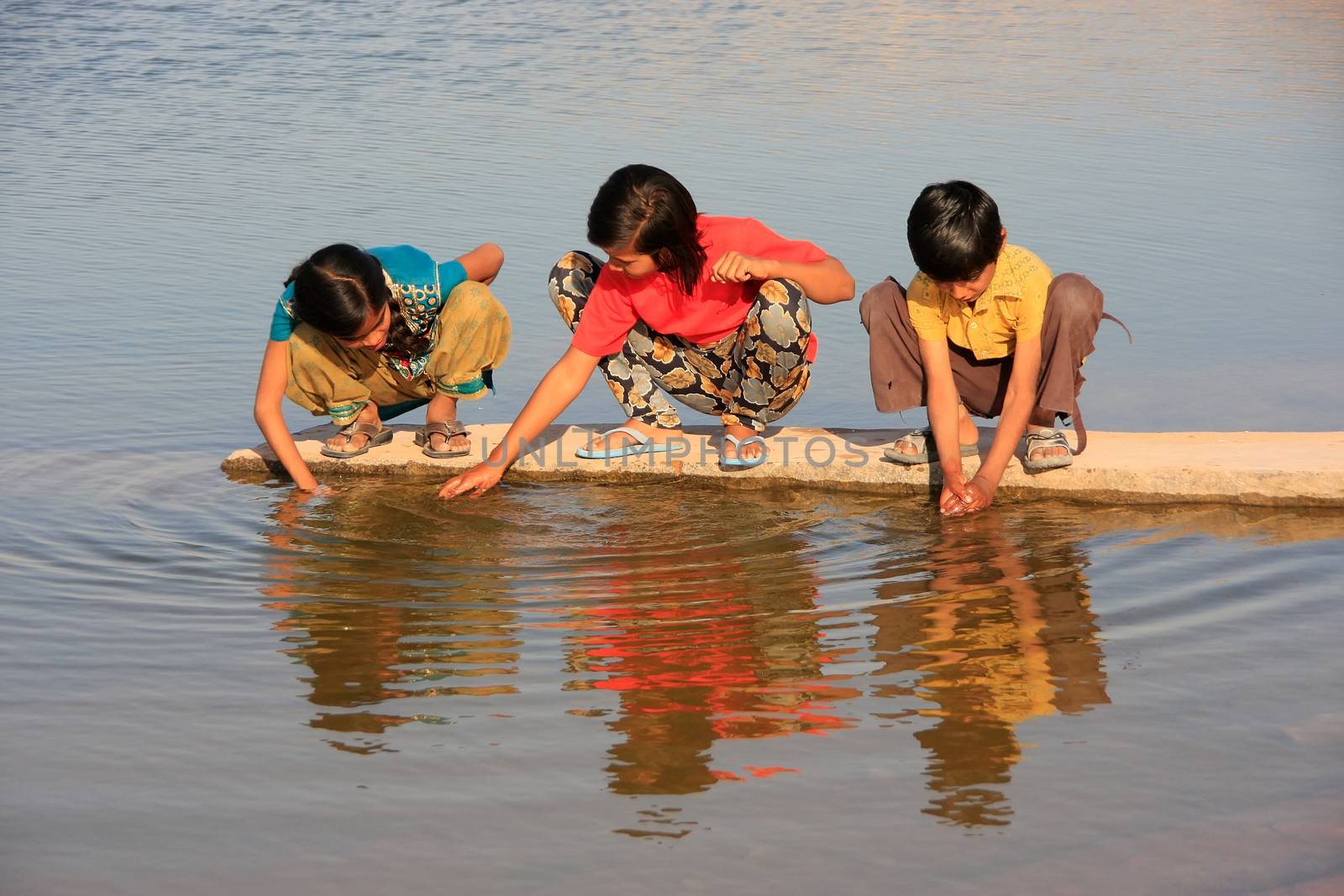Local kids drinking from water reservoir, Khichan village, India by donya_nedomam