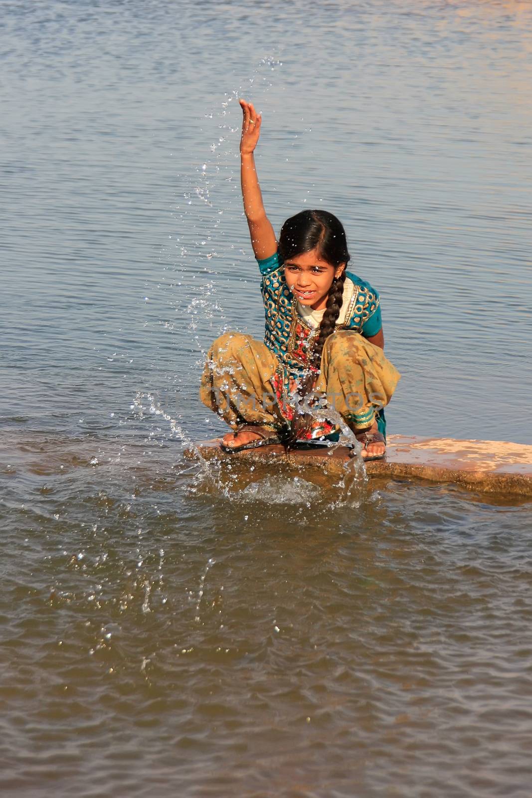 Local girl playing near water reservoir, Khichan village, Rajasthan, India