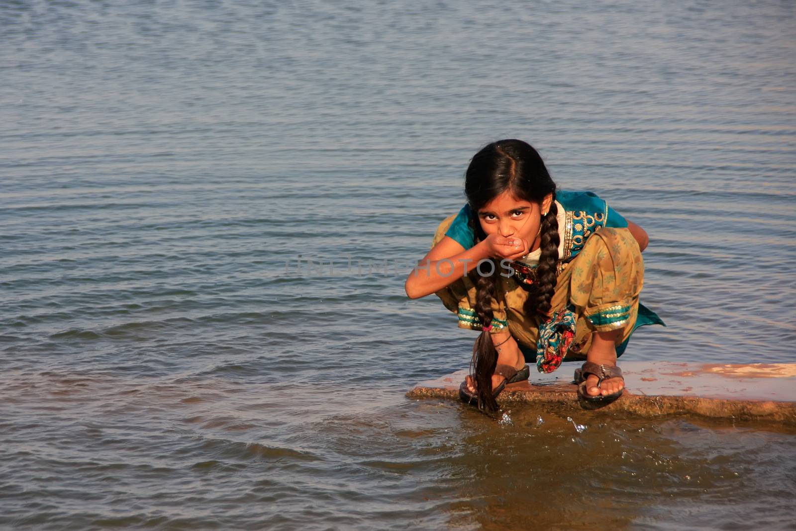 Local girl drinking from water reservoir, Khichan village, Rajasthan, India