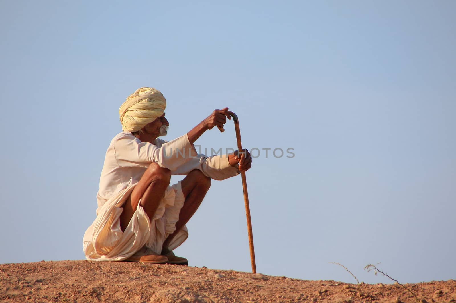 Local man sitting on a hill, Khichan village, India by donya_nedomam