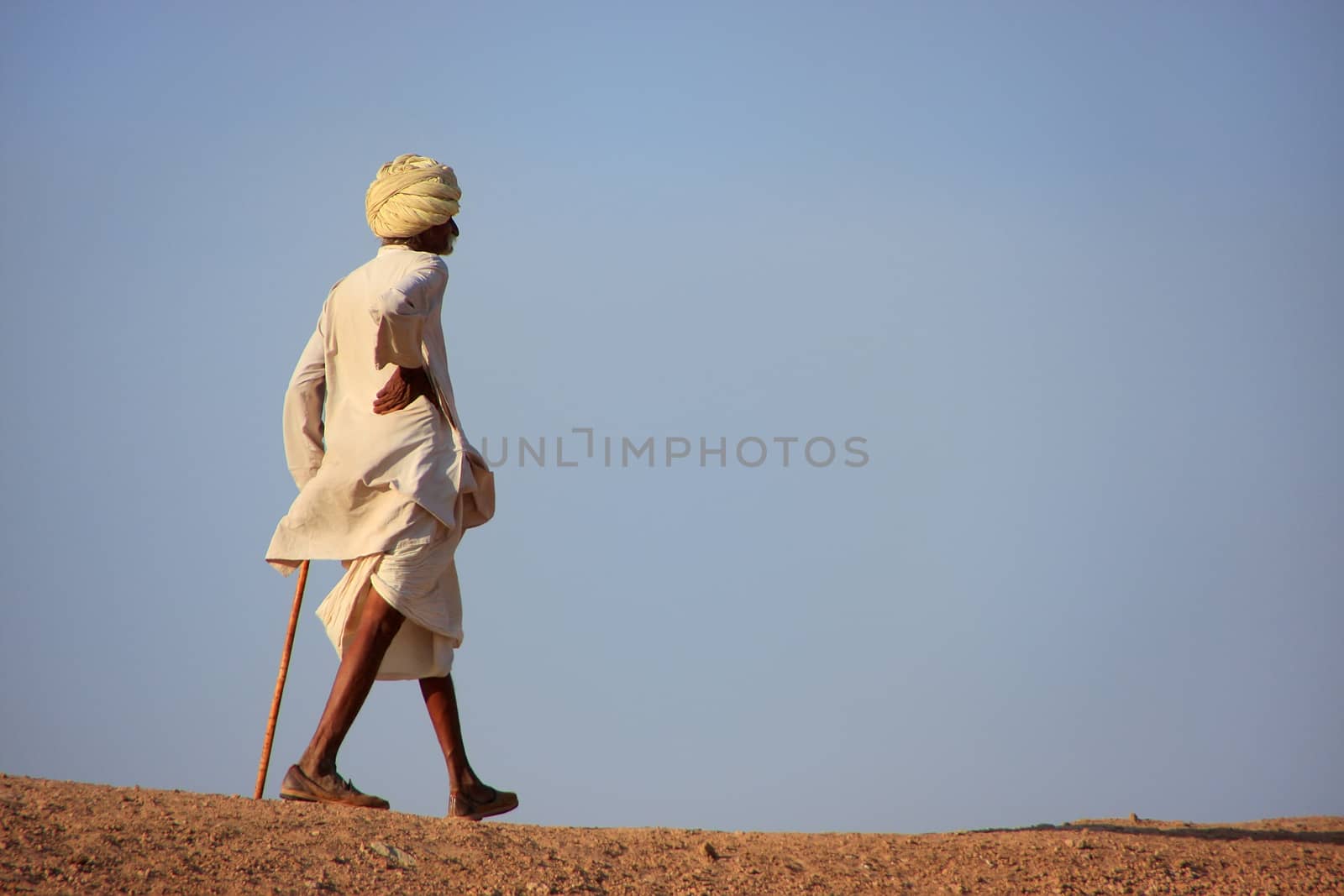 Local man walking on a hill, Khichan village, India by donya_nedomam