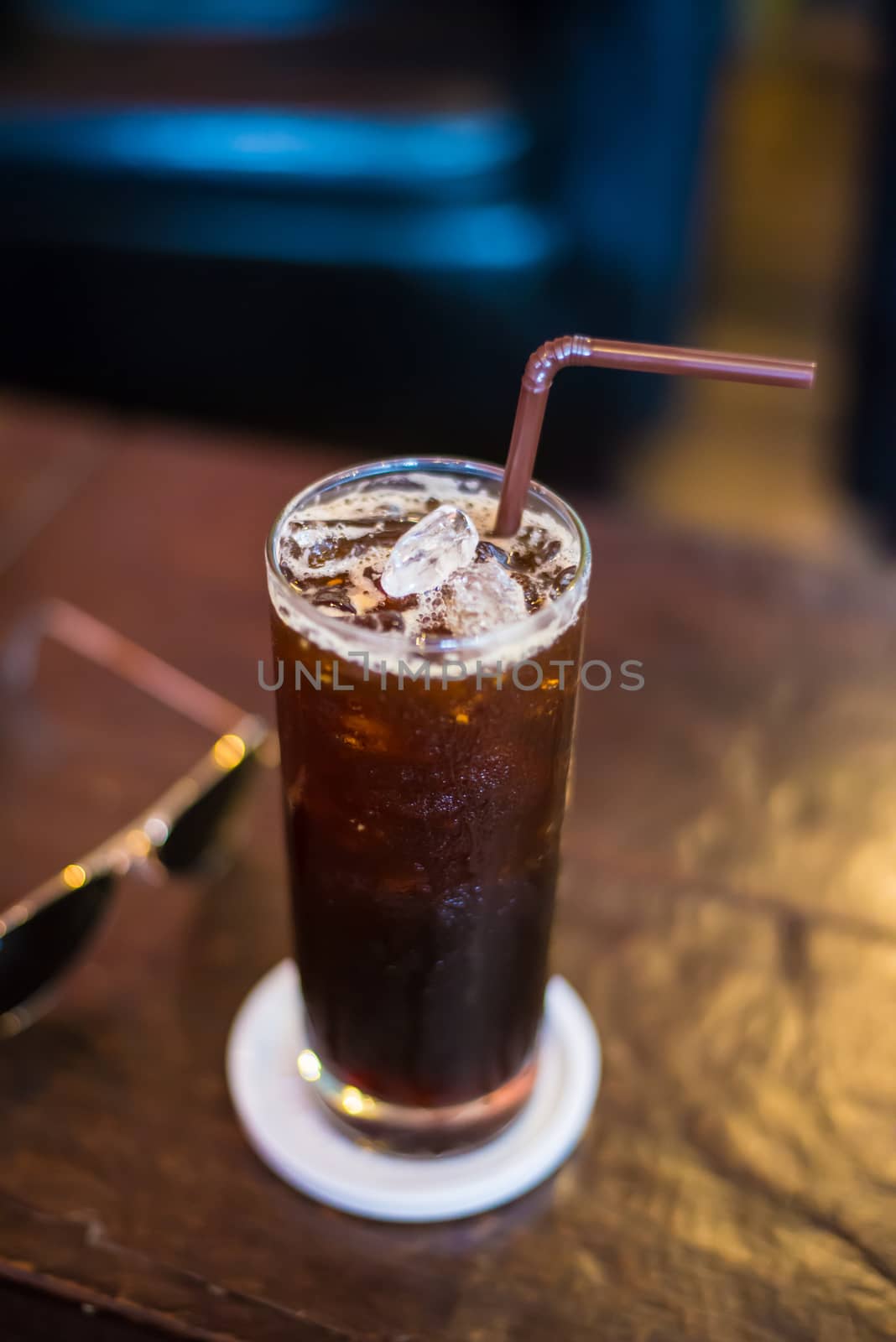 Ice black Coffee on the wooden table in the cafe.