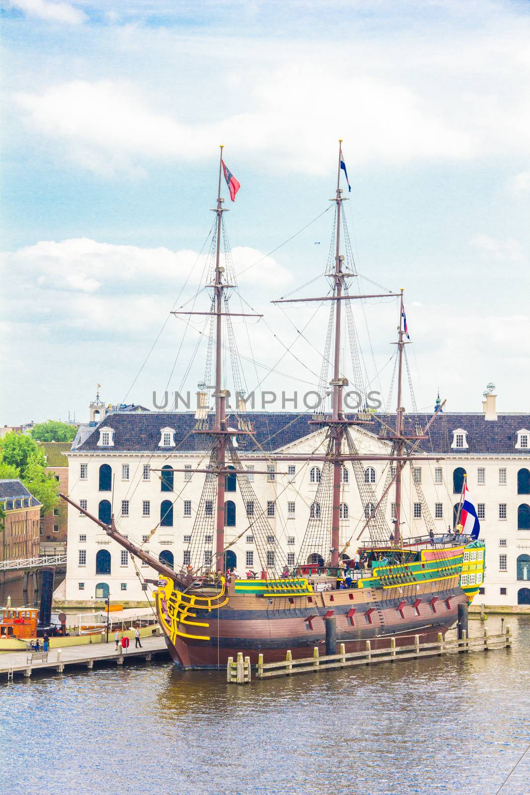 View of a rebuilt Indiaman ship and the Maritime museum in the Amsterdam Harbour by gianliguori