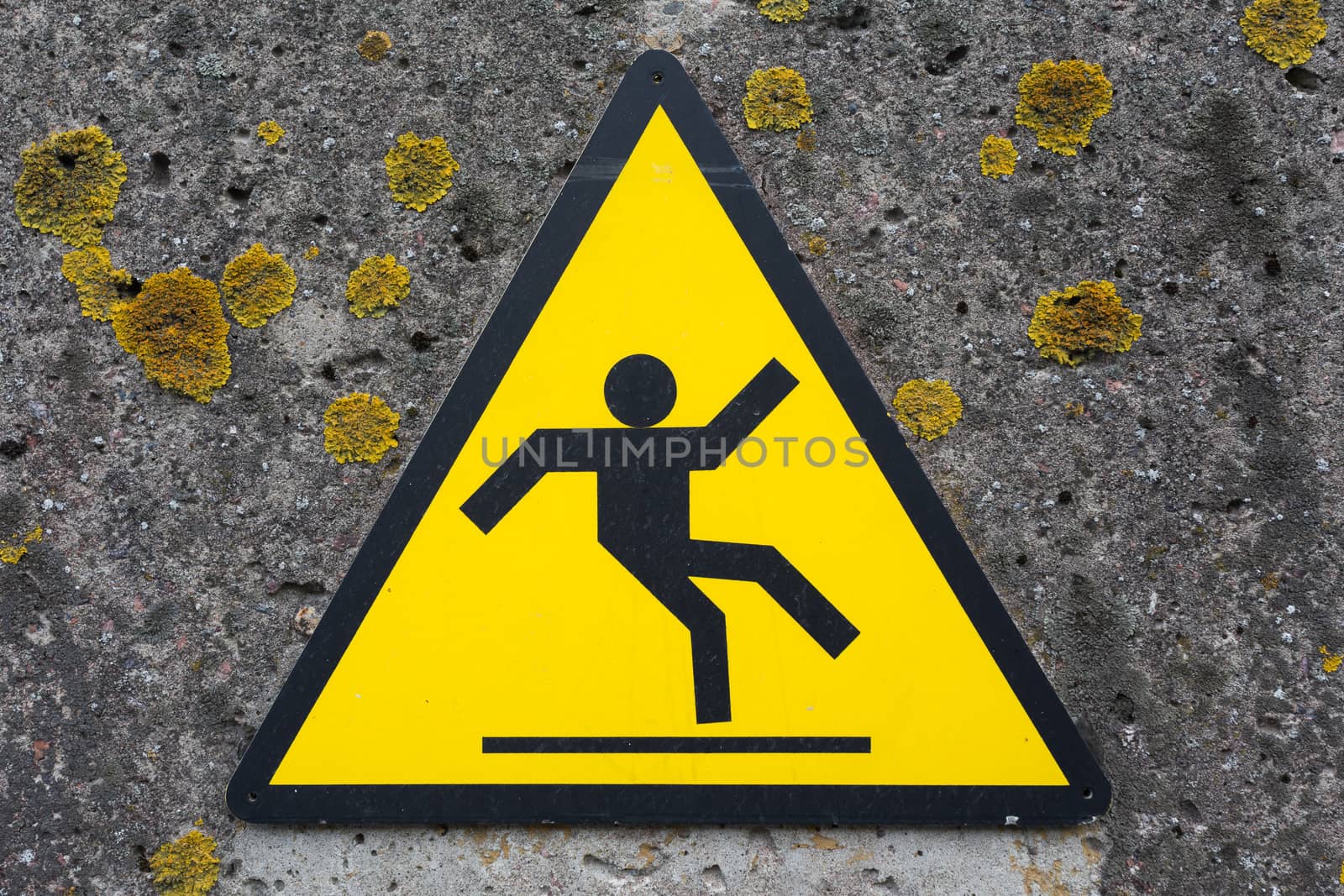Sign beware slippy on concrete wall