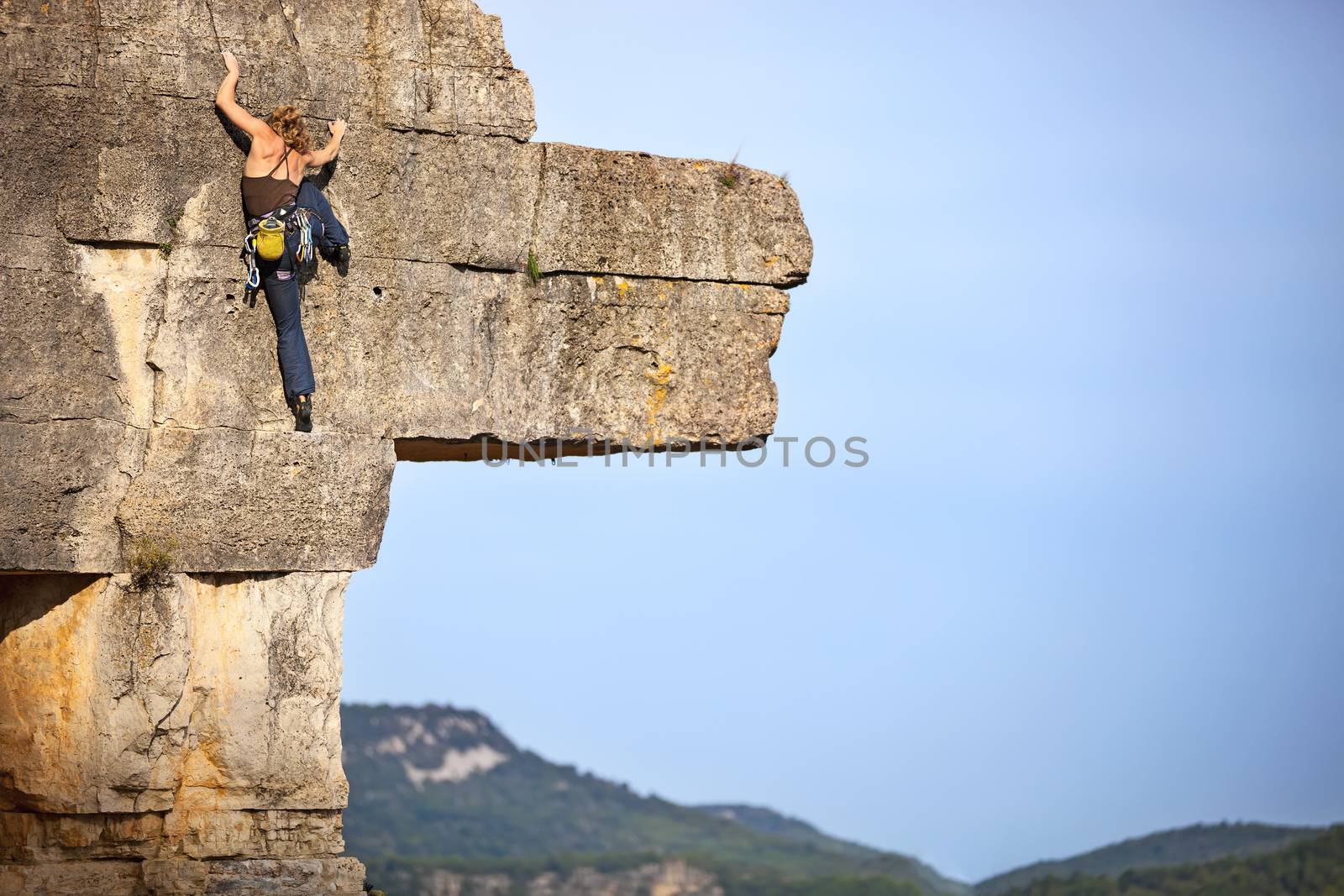 Young female free climber on face of a cliff
