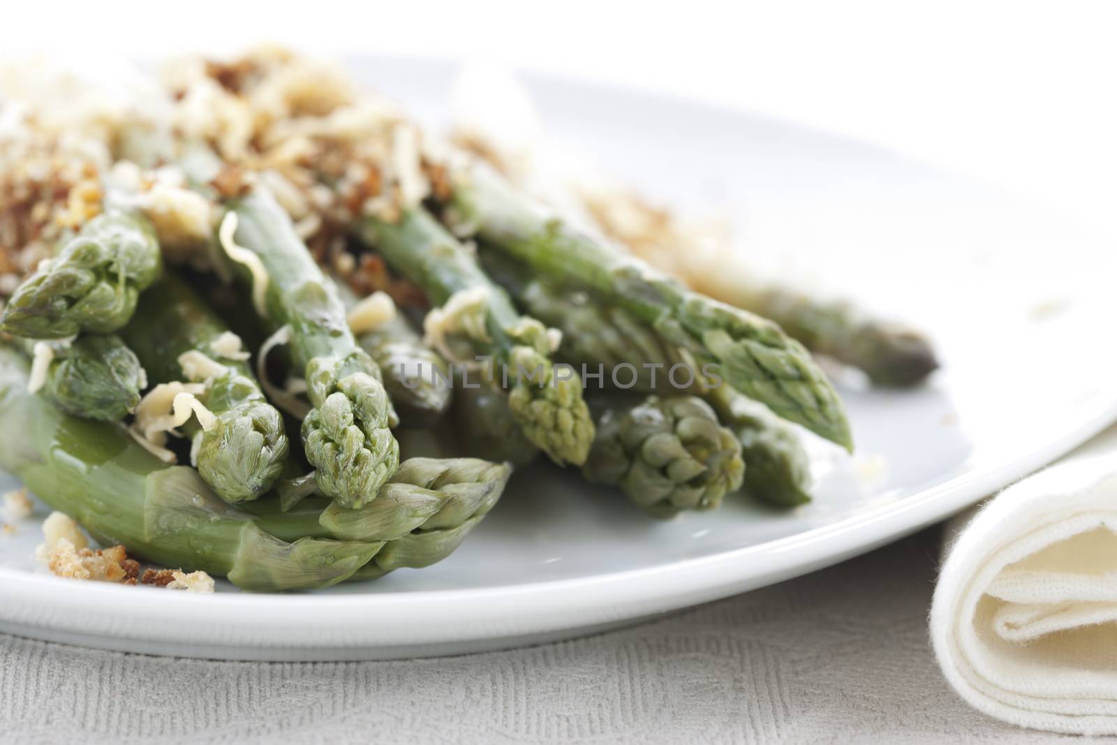 Asparagus gratin on white plate on white background